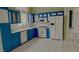 Bright kitchen with blue cabinets, white appliances, and tile flooring at 10528 Cogswell Ave, Las Vegas, NV 89134