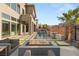 Stylish backyard featuring a pool with water feature, gas fire pit, lounge chairs, and well-manicured landscaping at 10632 Patina Hills Ct, Las Vegas, NV 89135