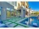 Backyard featuring a modern pool with lounge chairs, artificial turf, and view of the home's exterior at 10632 Patina Hills Ct, Las Vegas, NV 89135