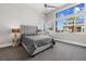 Bright bedroom with a gray bed, large window, and modern decor at 10632 Patina Hills Ct, Las Vegas, NV 89135