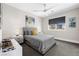 Cozy bedroom with a gray bed, modern ceiling fan, and natural light at 10632 Patina Hills Ct, Las Vegas, NV 89135