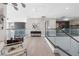 Second floor hallway with glass railing, light wood floors, modern lighting, and neutral decor at 10632 Patina Hills Ct, Las Vegas, NV 89135