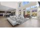 Expansive living room featuring a stylish sofa, tile floors, and seamless flow to the outdoor area at 10632 Patina Hills Ct, Las Vegas, NV 89135