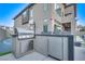 Outdoor kitchen with stainless steel grill and refrigerator, next to a basketball court and covered patio at 10632 Patina Hills Ct, Las Vegas, NV 89135