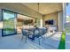 Covered patio with outdoor dining and lounge furniture, with a view to the kitchen through sliding glass doors at 10632 Patina Hills Ct, Las Vegas, NV 89135