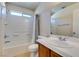 Bathroom showcasing tiled shower-tub combo and a sink with a large mirror at 1092 Slate Crossing Ln # 1, Henderson, NV 89002