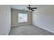 Bright bedroom features neutral carpeting, a ceiling fan, and a window with blinds for natural light at 1092 Slate Crossing Ln # 1, Henderson, NV 89002