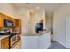 Kitchen with wood cabinetry, breakfast bar, and black appliances under recessed lighting at 1092 Slate Crossing Ln # 1, Henderson, NV 89002