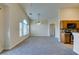 Spacious living room view with gray carpet and open layout to kitchen featuring wood cabinets at 1092 Slate Crossing Ln # 1, Henderson, NV 89002