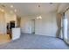 Open living area featuring gray carpet, neutral walls, and kitchen with stainless steel appliances at 1092 Slate Crossing Ln # 1, Henderson, NV 89002