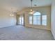 Open-concept living room with doors to backyard and arched window and neutral colored carpet at 1092 Slate Crossing Ln # 1, Henderson, NV 89002