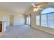 Spacious carpeted living room featuring a ceiling fan, large windows, and french doors at 1092 Slate Crossing Ln # 1, Henderson, NV 89002