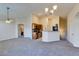 Cozy living room view with gray carpet and open layout to kitchen with wood cabinets at 1092 Slate Crossing Ln # 1, Henderson, NV 89002