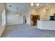 Bright living room view featuring gray carpet and open layout to kitchen with wood cabinets at 1092 Slate Crossing Ln # 1, Henderson, NV 89002