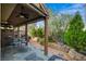 Covered back patio features brick flooring, outdoor seating, a ceiling fan, and a lush, landscaped garden area at 1209 Padre Serra Ln, Las Vegas, NV 89134