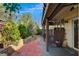 Back patio featuring brick flooring, a covered area, and a landscaped backyard for outdoor enjoyment at 1209 Padre Serra Ln, Las Vegas, NV 89134