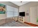 Bedroom with a window, hardwood floors, TV on a white stand, closet, and a twin bed with grey bedding at 1209 Padre Serra Ln, Las Vegas, NV 89134