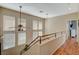 Upper-level hallway with natural light, wood floors, and access to bedrooms at 1209 Padre Serra Ln, Las Vegas, NV 89134