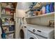 Laundry room featuring a washer, dryer, and shelving stocked with cleaning supplies and household items at 1209 Padre Serra Ln, Las Vegas, NV 89134