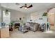 Cozy living room with a gray sofa, fireplace, neutral walls, and a ceiling fan at 1209 Padre Serra Ln, Las Vegas, NV 89134