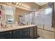 Bathroom with a double sink vanity, large mirror, and a shower-tub combo with a sliding glass door at 1209 Padre Serra Ln, Las Vegas, NV 89134