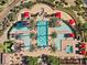 Aerial view of pool area with lounge chairs, red umbrellas, palm trees and lush gardens at 16 Via Visione # 101, Henderson, NV 89011