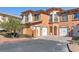 Inviting multi-level townhome featuring a private 2-car garage and beautiful terracotta-toned stucco at 16 Via Visione # 101, Henderson, NV 89011