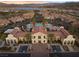 An aerial view shows a community building with a pool, red awnings, meticulous landscaping, and mountain and lake views at 16 Via Visione # 101, Henderson, NV 89011