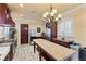 Bright kitchen featuring custom cabinets, a butcher block island, stainless appliances, and a chandelier at 16 Via Visione # 101, Henderson, NV 89011