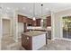 Bright kitchen featuring granite counters, stone-clad island, stainless appliances, and custom cabinetry at 16 Via Visione # 101, Henderson, NV 89011