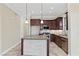 Well-lit kitchen with granite counters, stone-clad island, stainless appliances, and modern cabinetry at 16 Via Visione # 101, Henderson, NV 89011