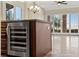 Kitchen island with beverage cooler, stone countertops, and views of living area and the backyard at 16 Via Visione # 101, Henderson, NV 89011