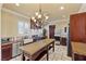 Bright kitchen featuring custom cabinets, a butcher block island, stainless appliances, and a chandelier at 16 Via Visione # 101, Henderson, NV 89011