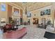 Open concept living room featuring ornate ceiling, multiple windows, large art pieces, and tiled floor at 16 Via Visione # 101, Henderson, NV 89011