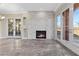 Bright living room with stacked stone fireplace, tile floors, and access to outdoor space via French doors at 16 Via Visione # 101, Henderson, NV 89011