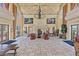 Elegant living room with high ceilings, ornate details, fireplace, and natural light from multiple windows at 16 Via Visione # 101, Henderson, NV 89011