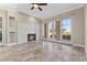 Open living room with stone fireplace, tile flooring, ceiling fan and beautiful view outside of French doors at 16 Via Visione # 101, Henderson, NV 89011