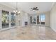 Bright living room with fireplace, tile floors, ceiling fan and doors leading to outdoor patio at 16 Via Visione # 101, Henderson, NV 89011