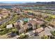 An aerial view captures a community pool surrounded by red awnings, landscaping, and beautiful homes and mountain views at 16 Via Visione # 101, Henderson, NV 89011