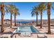 A beautiful pool area with palm trees, lake views, lounge chairs, and outdoor pavilions at 16 Via Visione # 101, Henderson, NV 89011