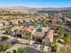 An aerial view showcases a community pool with lush landscaping, red awnings, and beautiful mountain views at 16 Via Visione # 101, Henderson, NV 89011