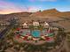 An elevated aerial view showcases a luxurious community pool with red awnings, water features, and mountain views at 16 Via Visione # 101, Henderson, NV 89011