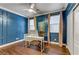 Office space featuring blue wall panels, modern desk and large windows with curtains at 1754 Quiver Point Ave, Henderson, NV 89012