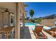 Resort-style pool area with rock waterfall, covered patio, and lounge chairs at 1754 Quiver Point Ave, Henderson, NV 89012