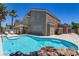 Backyard oasis with sparkling pool, palm trees, and covered patio at 1754 Quiver Point Ave, Henderson, NV 89012