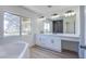 Luxurious bathroom featuring a large window for natural light, double sinks, and a soaking tub at 2032 Jesse Scott St, Las Vegas, NV 89106