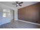 A spacious living room featuring modern flooring, a ceiling fan, and a unique accent wall for design at 2032 Jesse Scott St, Las Vegas, NV 89106