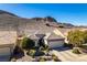 This house features a two car garage, desert landscaping, and mountain views at 2035 King Mesa Dr, Henderson, NV 89012