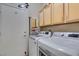 Bright laundry room equipped with modern washer and dryer units and storage cabinets at 2035 King Mesa Dr, Henderson, NV 89012