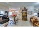 Warm living room featuring tile flooring, a brown leather sofa, and views into the dining and kitchen areas at 2035 King Mesa Dr, Henderson, NV 89012